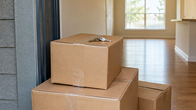 Boxes in front of a front door with housekeys on top