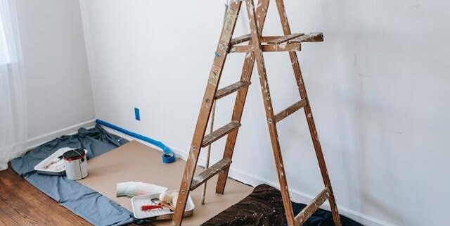a-ladder-and-paint-supplies-set-up-against-a-wall