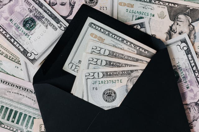 money-spread-out-behind-a-blank-envolope-with-money-inside money-spread-out-behind-a-blank-envolope-with-money-inside