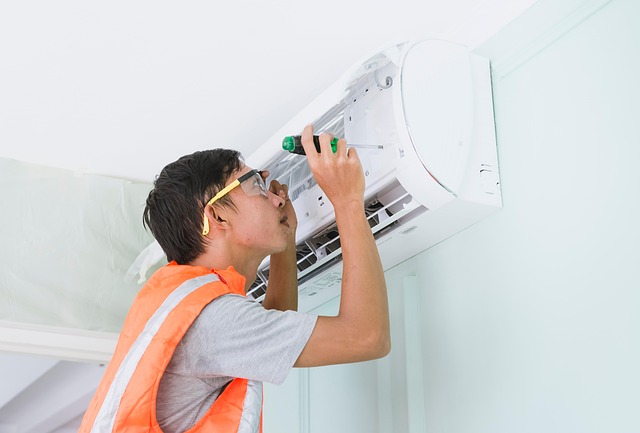 person repairing an air conditioner person repairing an air conditioning unit