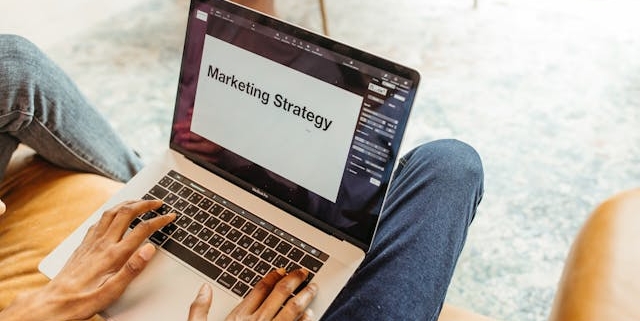person-typing-on-a-laptop-with-marketing-strategy-displayed-on-the-screen person-typing-on-a-laptop-with-marketing-strategy-displayed-on-the-screen