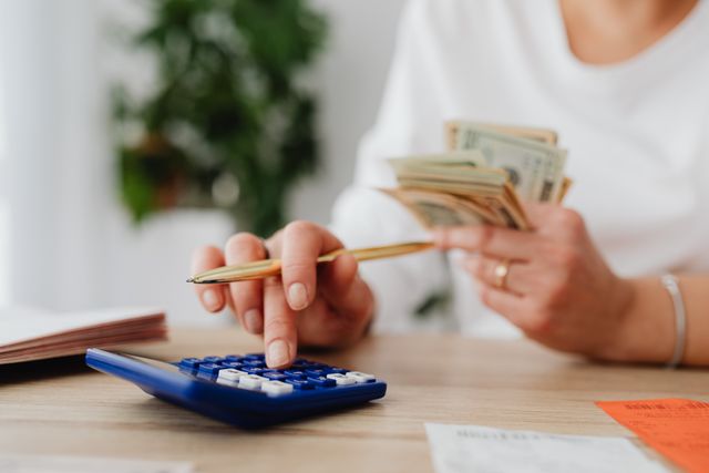 person with a calculator and cash