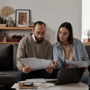 Close up of hands reviewing a rental application and calculating tenant screening costs.